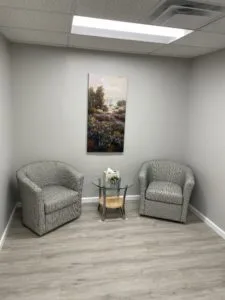 Two sofa chairs, a poster inside the room